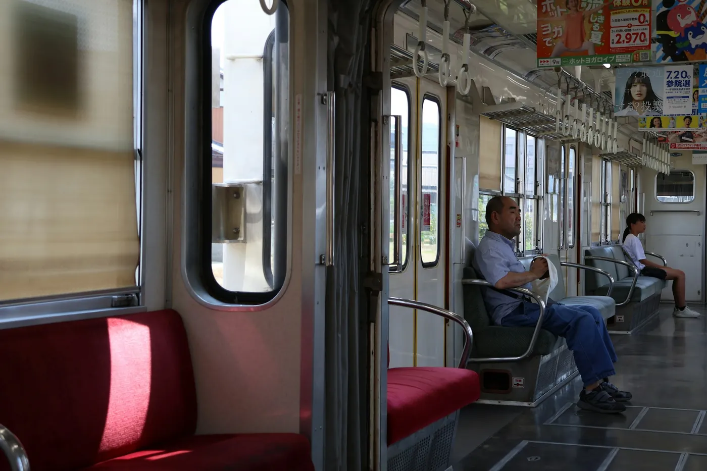 A passenger sitting at the end of a bench seat, next to the partition