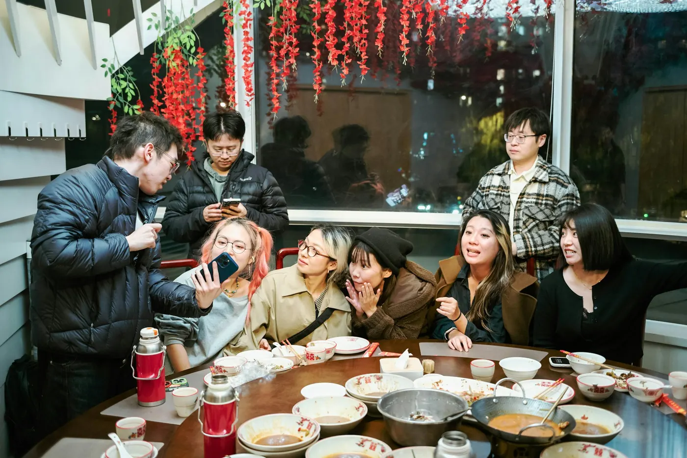 A group of friends eating together in a busy restaurant
