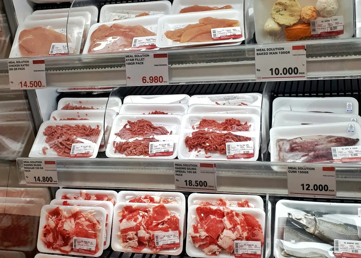 Packs of raw meat in a supermarket fridge