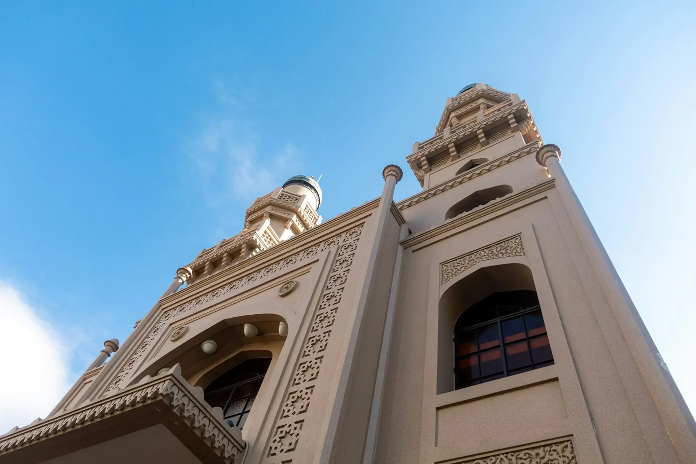 A white mosque with minarets against a blue sky