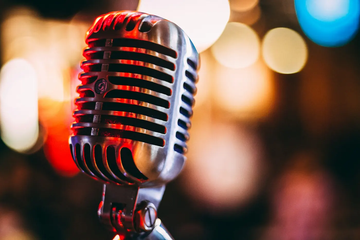 A vintage microphone in front of warm city lights